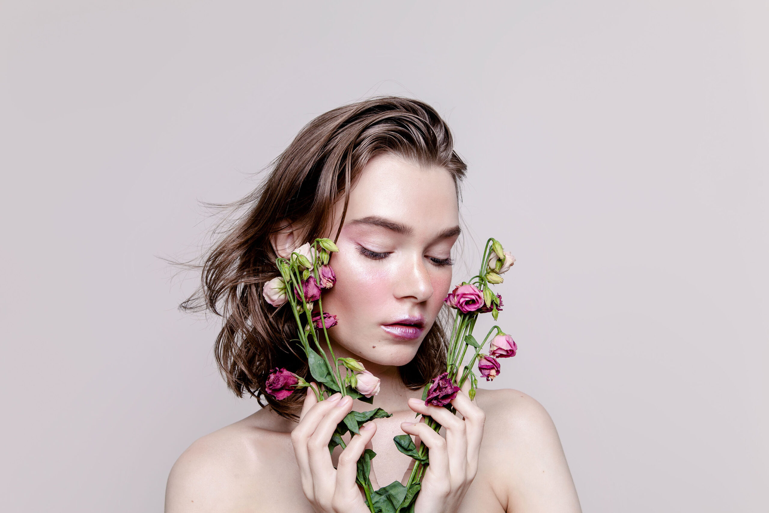 Beautiful young woman with creative artistic make-up and flowers in her hand Freshness Beauty Ileezon